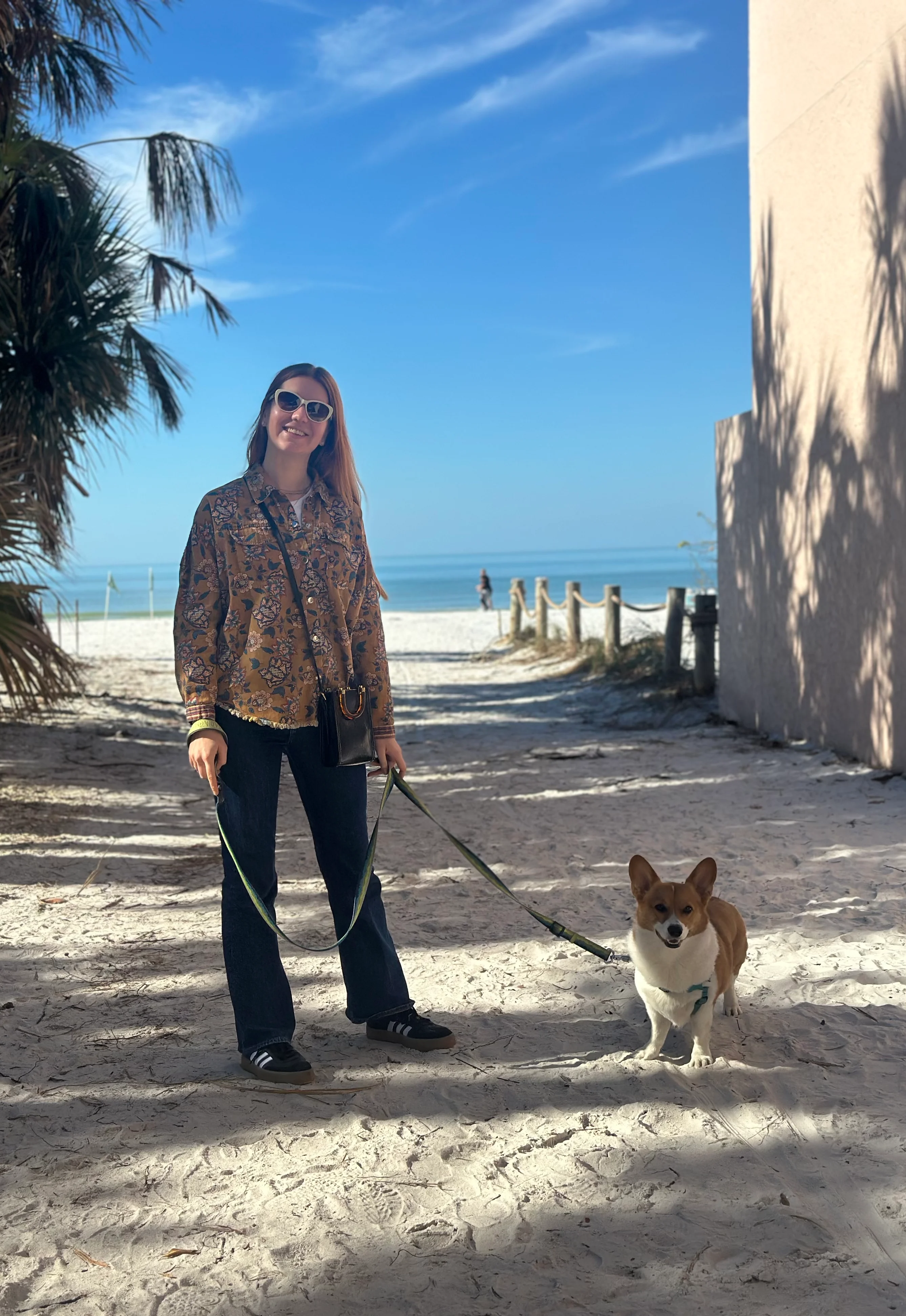 Anastasiia with her corgi on the beach